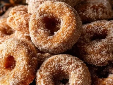 Freshly baked apple donuts topped with cinnamon sugar and apple slices