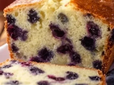 Delicious slice of BEST Lemon Blueberry Bread topped with fresh blueberries