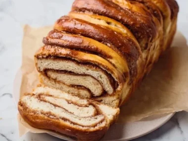 Loaf of freshly baked cinnamon swirl bread with a rich, swirled topping