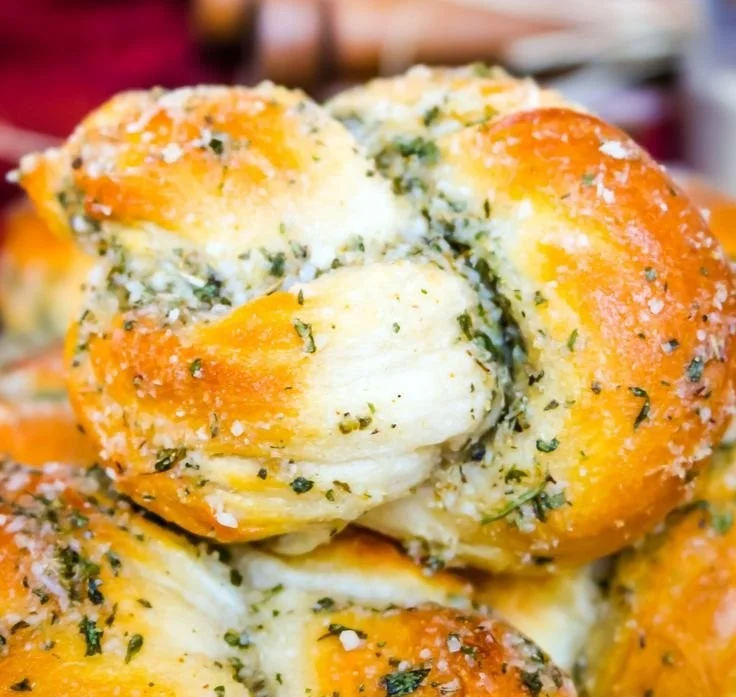 Freshly baked Parmesan Garlic Knots topped with garlic and herbs