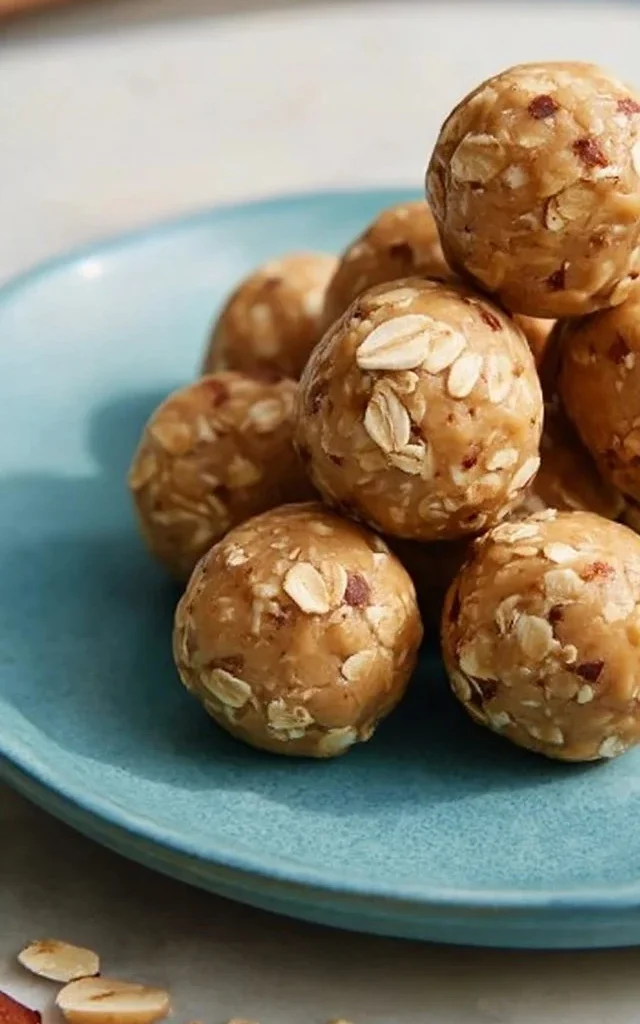 A close-up of Peanut Butter Energy Balls on a wooden table, showcasing their texture.