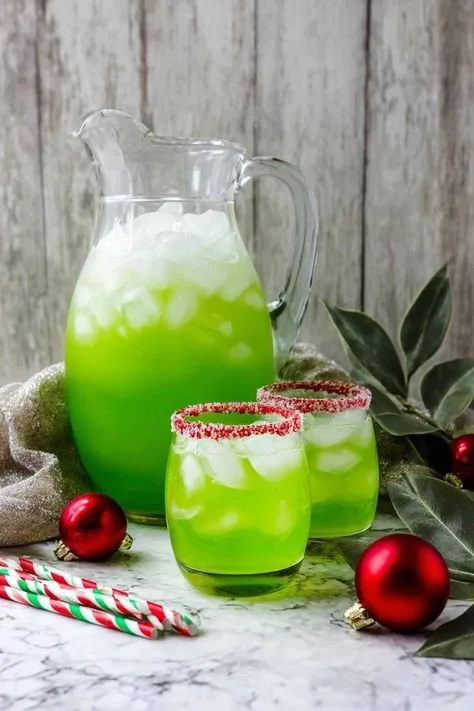 Festive Grinch Punch in a holiday-themed glass with colorful ingredients.