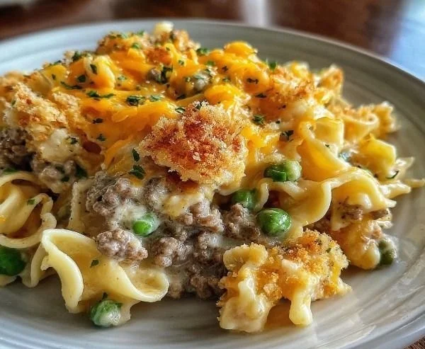 Sour Cream Beef Noodle Casserole in a baking dish topped with cheese