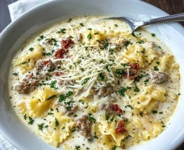 Bowl of creamy Alfredo Lasagna Soup topped with cheese and herbs