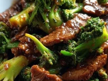 Beef and broccoli stir fry served in a bowl with a side of rice