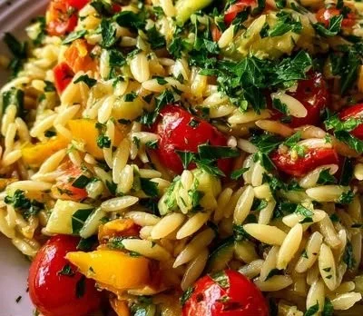 Delicious orzo dinner served with fresh vegetables and herbs