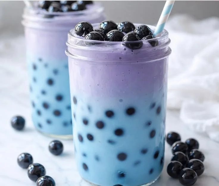 A vibrant Butterfly Blue Boba Tea with tapioca pearls and colorful butterfly pea flower.