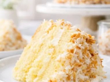 Irresistibly moist and creamy Coconut Custard Cake slice on a plate
