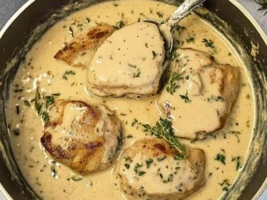 Creamy garlic pork medallions served on a plate with herbs