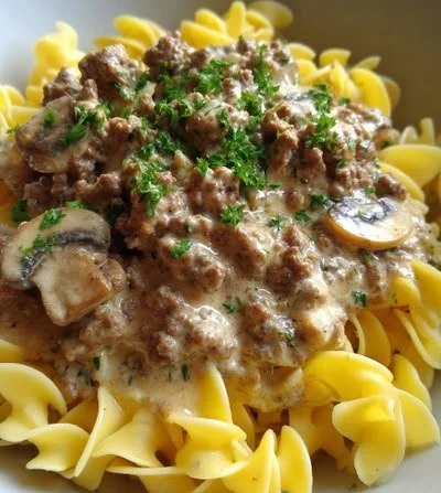 Plate of Easy Ground Beef Stroganoff served with noodles and garnished with parsley