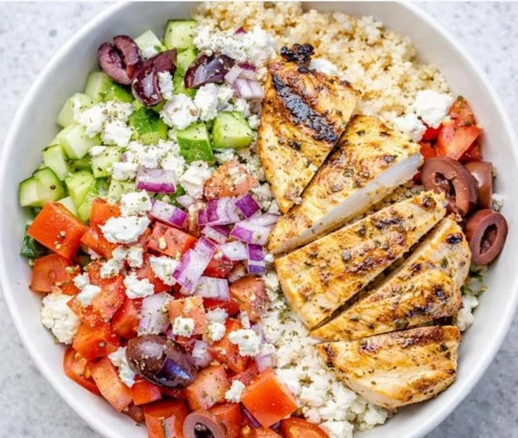 A delicious Greek Chicken Bowl filled with fresh vegetables and grilled chicken.