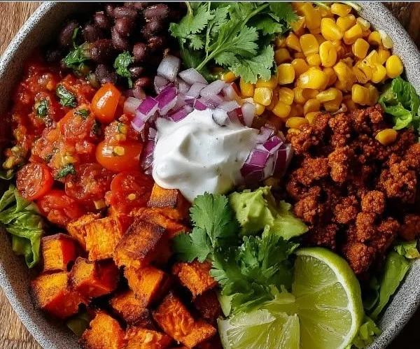 Roasted sweet potato and black bean bowl garnished with fresh herbs