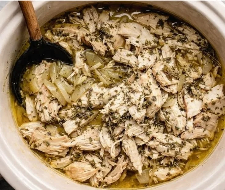 Delicious slow cooker Greek chicken dish served with fresh herbs and lemon.
