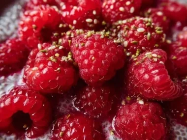 Vegan raspberry chia pudding in a glass topped with fresh raspberries