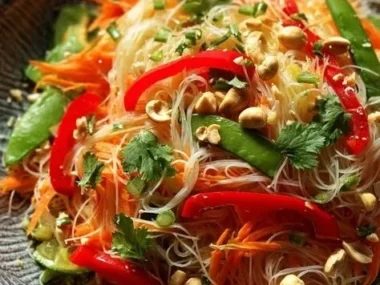 Colorful Asian noodle salad with fresh vegetables and herbs
