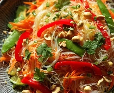 Colorful Asian noodle salad with fresh vegetables and herbs