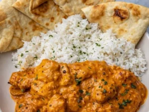 Delicious butter chicken served with rice and naan bread