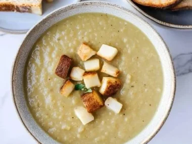 Bowl of creamy cauliflower potato leek soup topped with fresh herbs