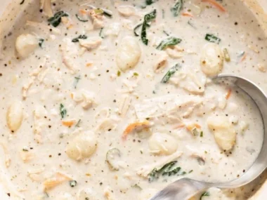 Creamy chicken gnocchi soup garnished with herbs in a bowl