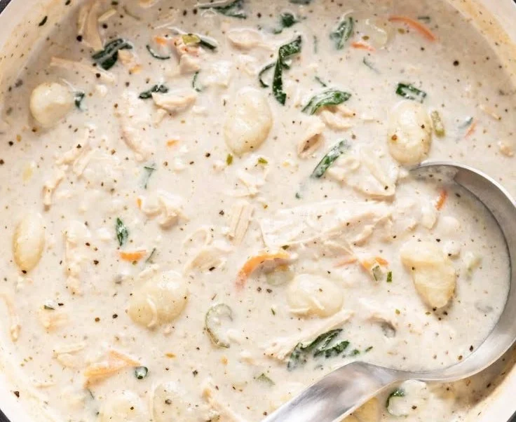 Creamy chicken gnocchi soup garnished with herbs in a bowl
