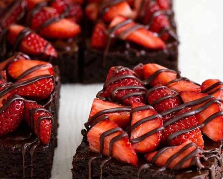 Delicious chocolate-covered strawberry brownies topped with fresh strawberries.