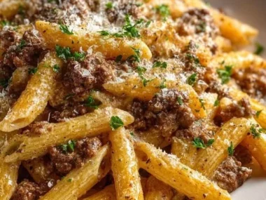 Creamy beef pasta dish served in a bowl with garnishes.