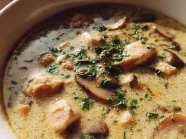 Creamy rotisserie chicken mushroom soup in a bowl garnished with herbs.