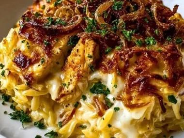 French Onion Chicken Orzo Casserole with melted cheese and caramelized onions.
