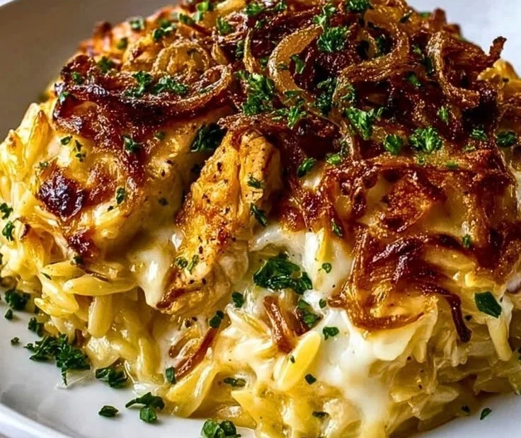 French Onion Chicken Orzo Casserole with melted cheese and caramelized onions.
