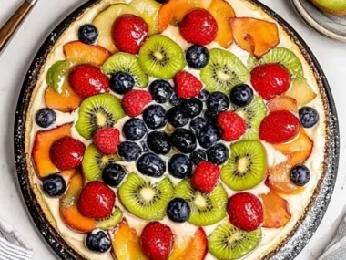 Colorful and delicious fruit pizza topped with fresh fruits and cream cheese.
