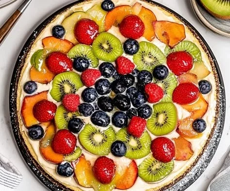 Colorful and delicious fruit pizza topped with fresh fruits and cream cheese.