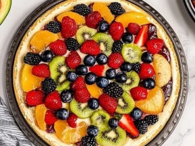 Delicious homemade fruit pizza topped with a variety of fresh fruits.