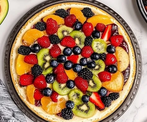 Delicious homemade fruit pizza topped with a variety of fresh fruits.