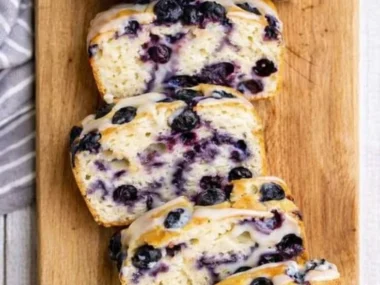 Homemade lemon blueberry bread on a wooden cutting board