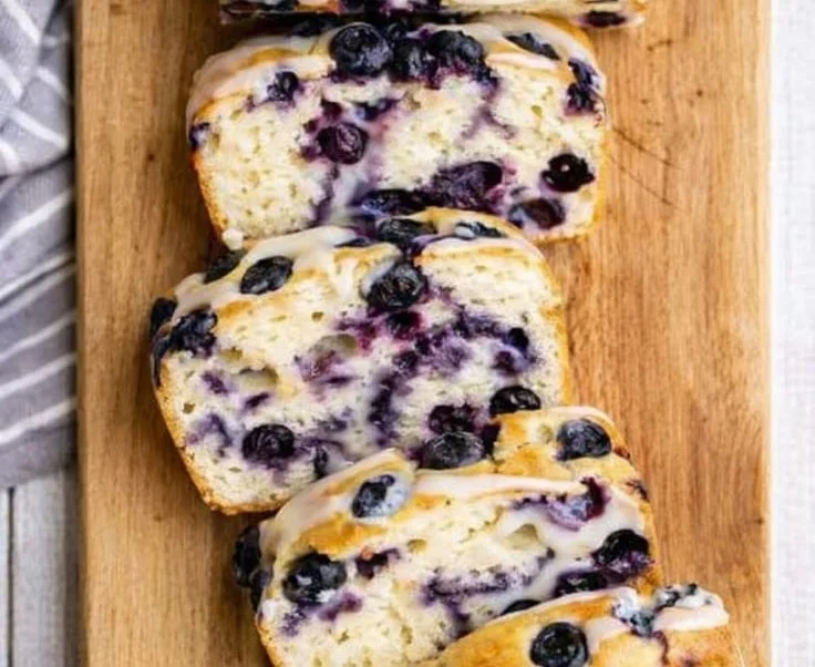 Homemade lemon blueberry bread on a wooden cutting board