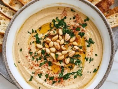 A bowl of delicious peanut butter hummus with fresh veggies for dipping.