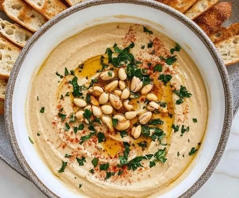 A bowl of delicious peanut butter hummus with fresh veggies for dipping.