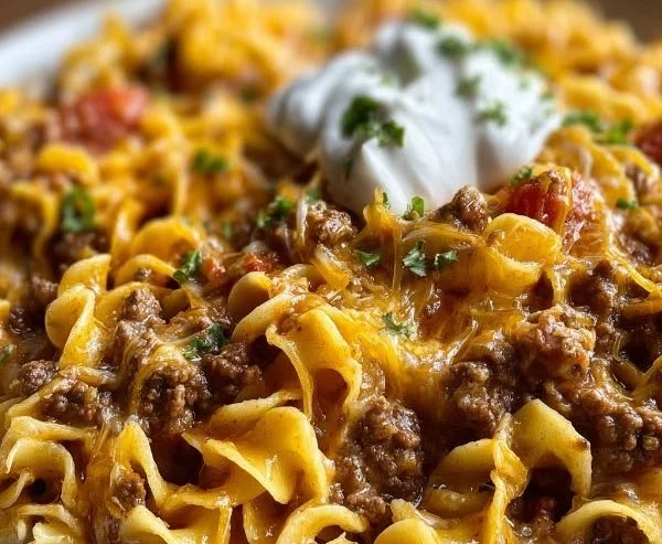 Sour Cream Beef Noodle Casserole served in a baking dish garnished with herbs.