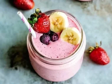 Delicious strawberry banana smoothie in a glass topped with fresh fruits