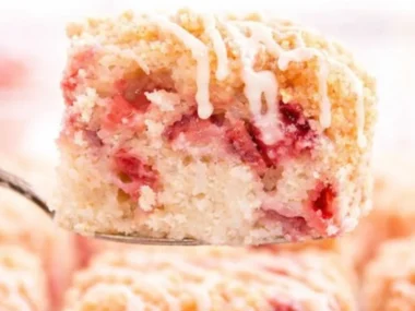 Deliciously moist Strawberry Rhubarb Cake topped with fresh strawberries and rhubarb.