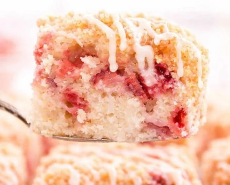 Deliciously moist Strawberry Rhubarb Cake topped with fresh strawberries and rhubarb.